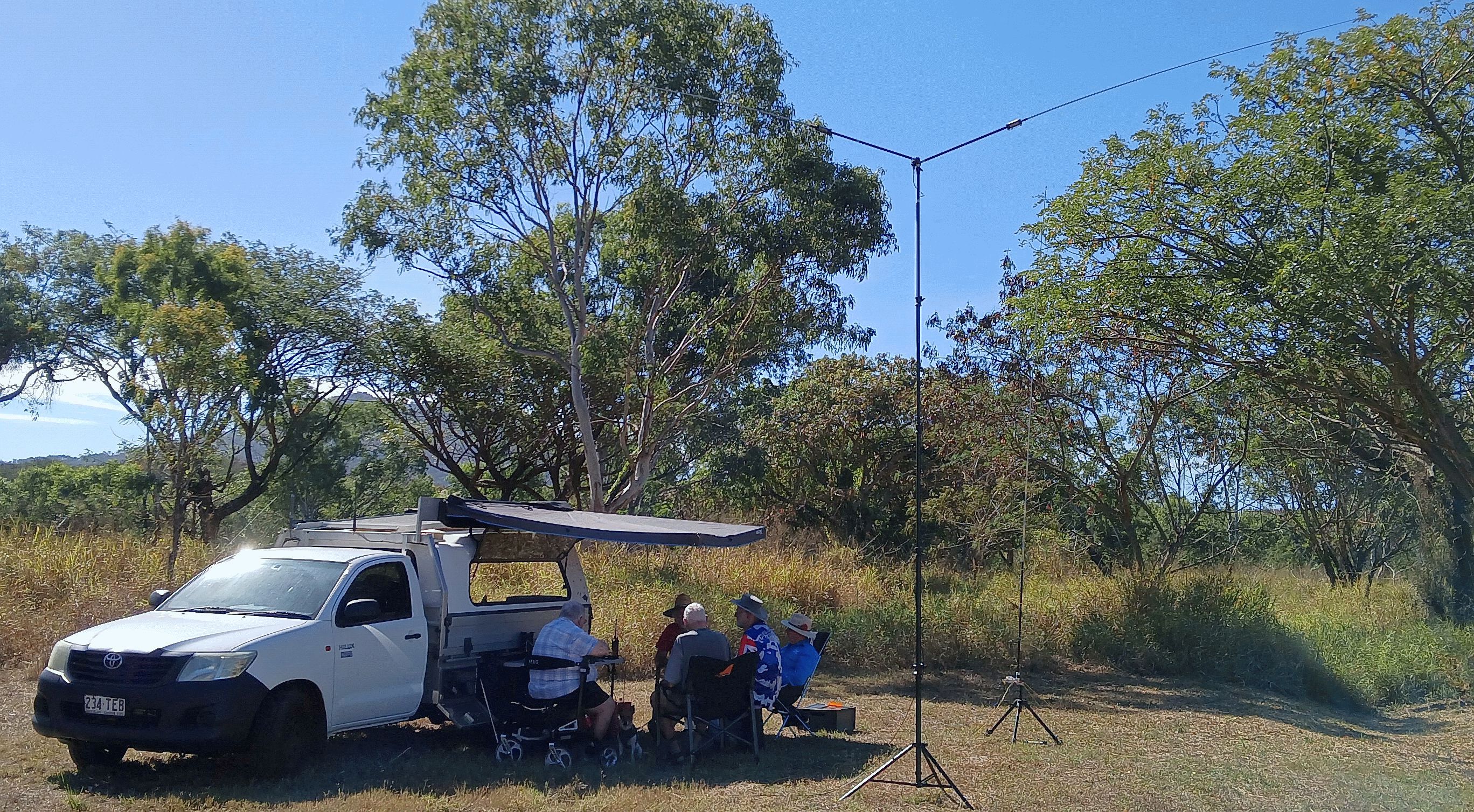 Field station set up under a vehicle awning with a Y antenna mast
