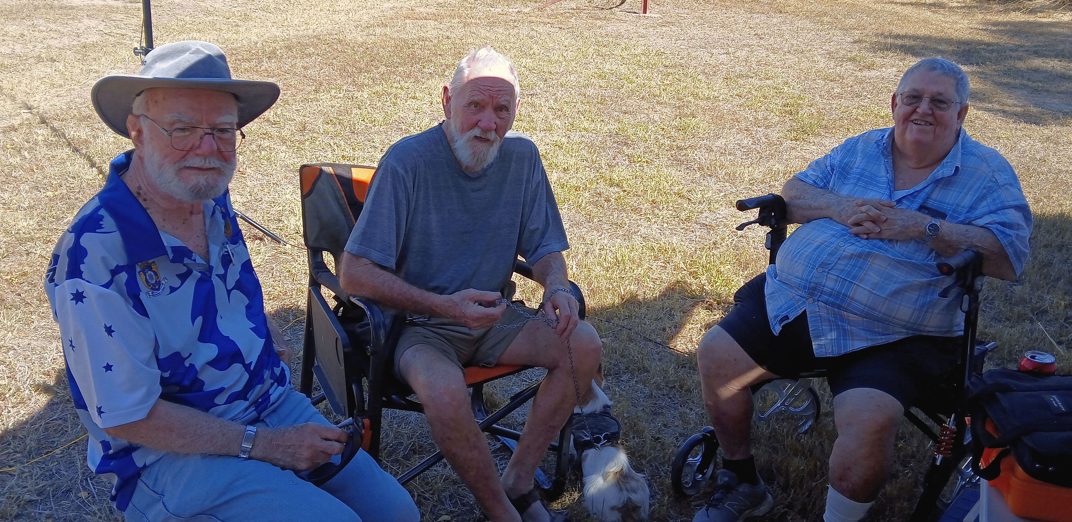 Club members chatting in camp chairs with a dog