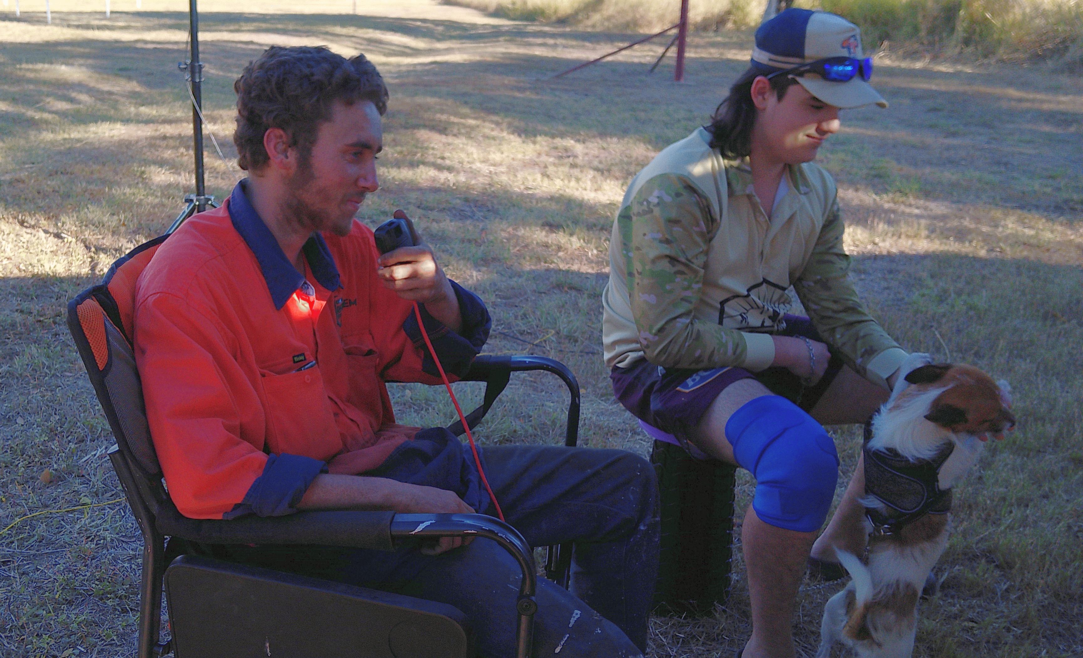 Two young operators with a handheld radio and a dog