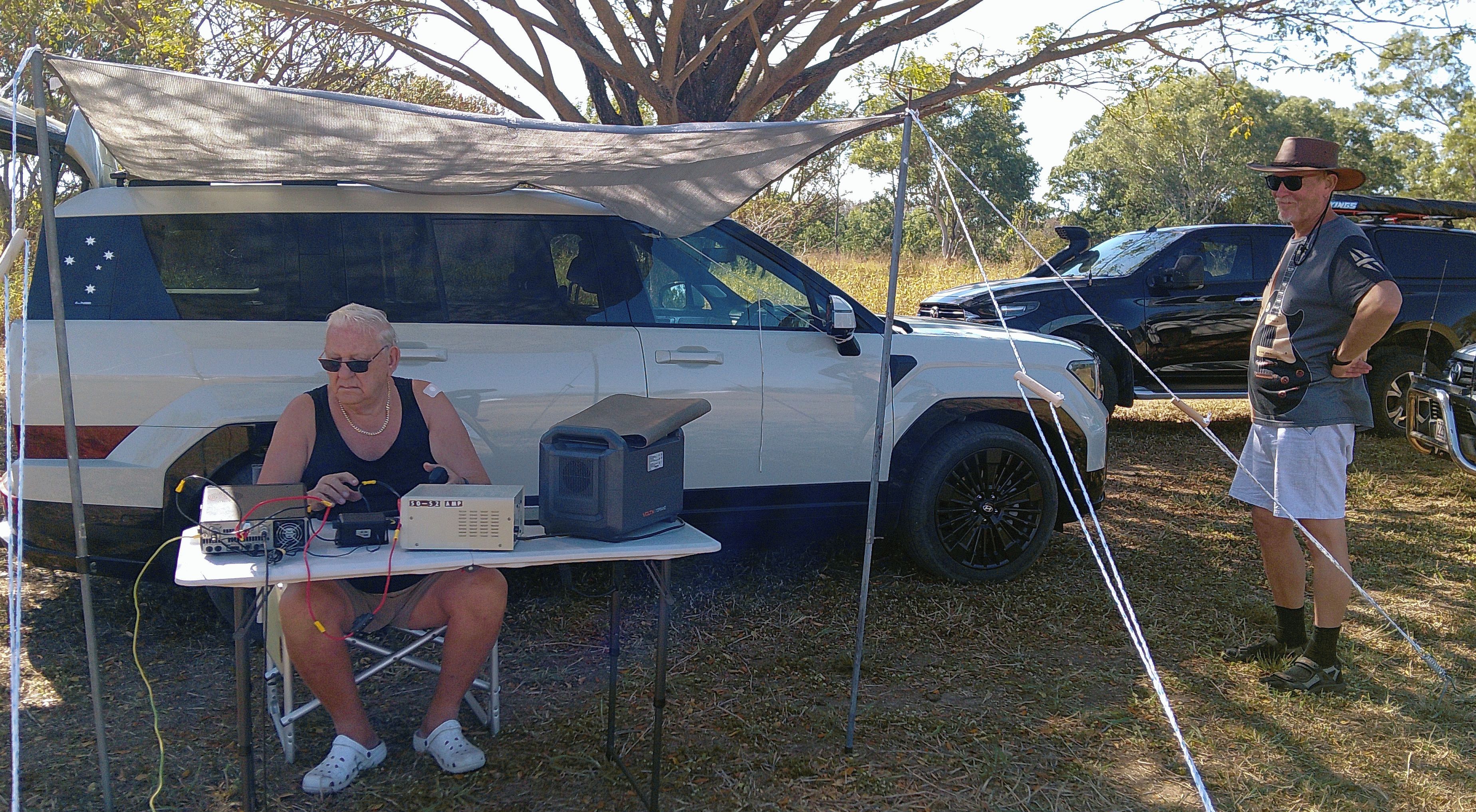 Operator at a portable HF station under an awning