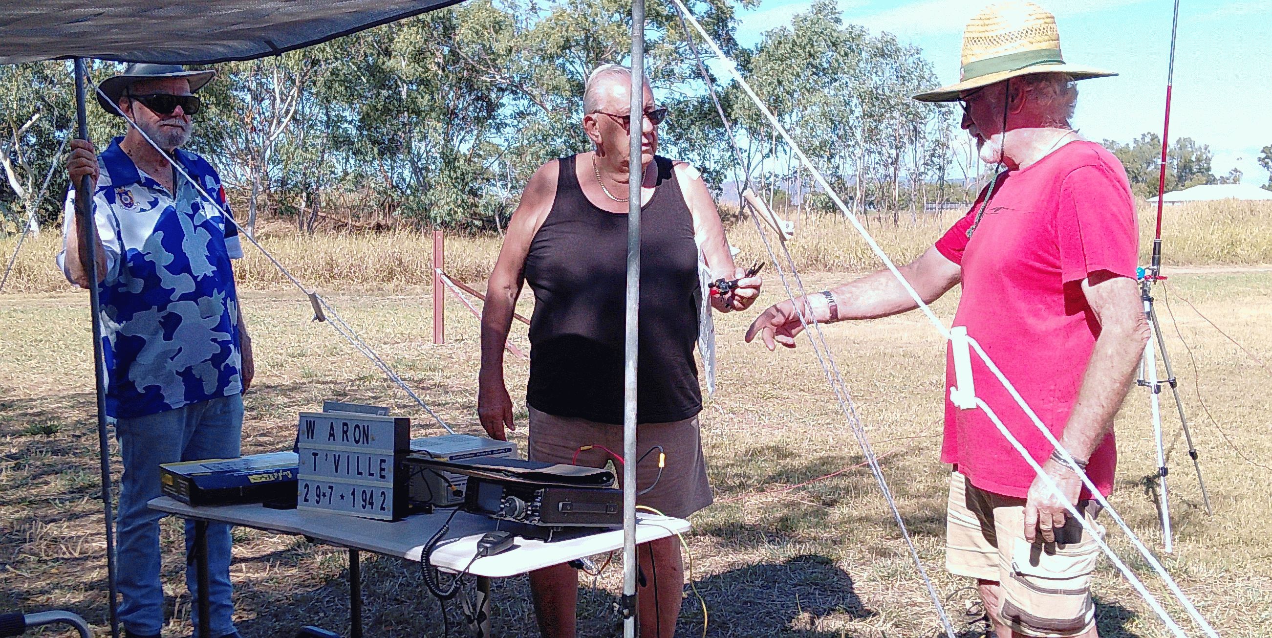 Members setting up equipment beside the anniversary sign