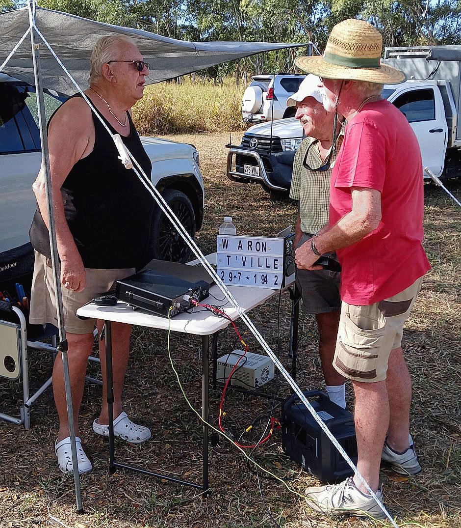 Members chatting around a station under an awning