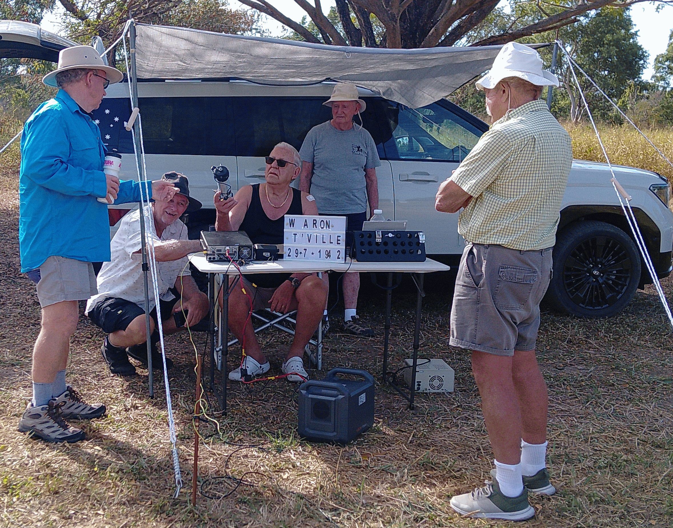 Group of members around a station and the anniversary sign