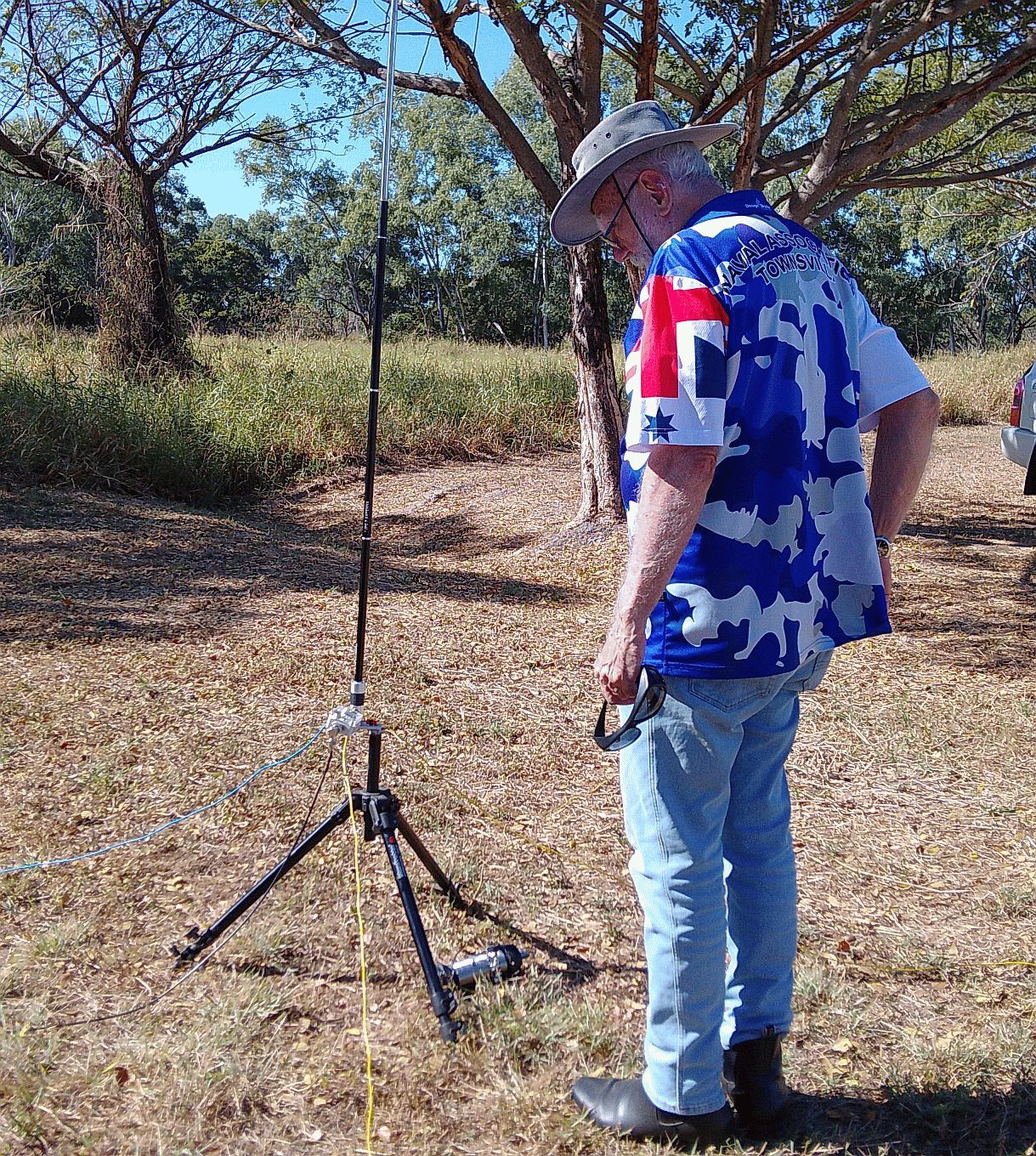 Member wearing a Naval Association Townsville shirt beside an antenna