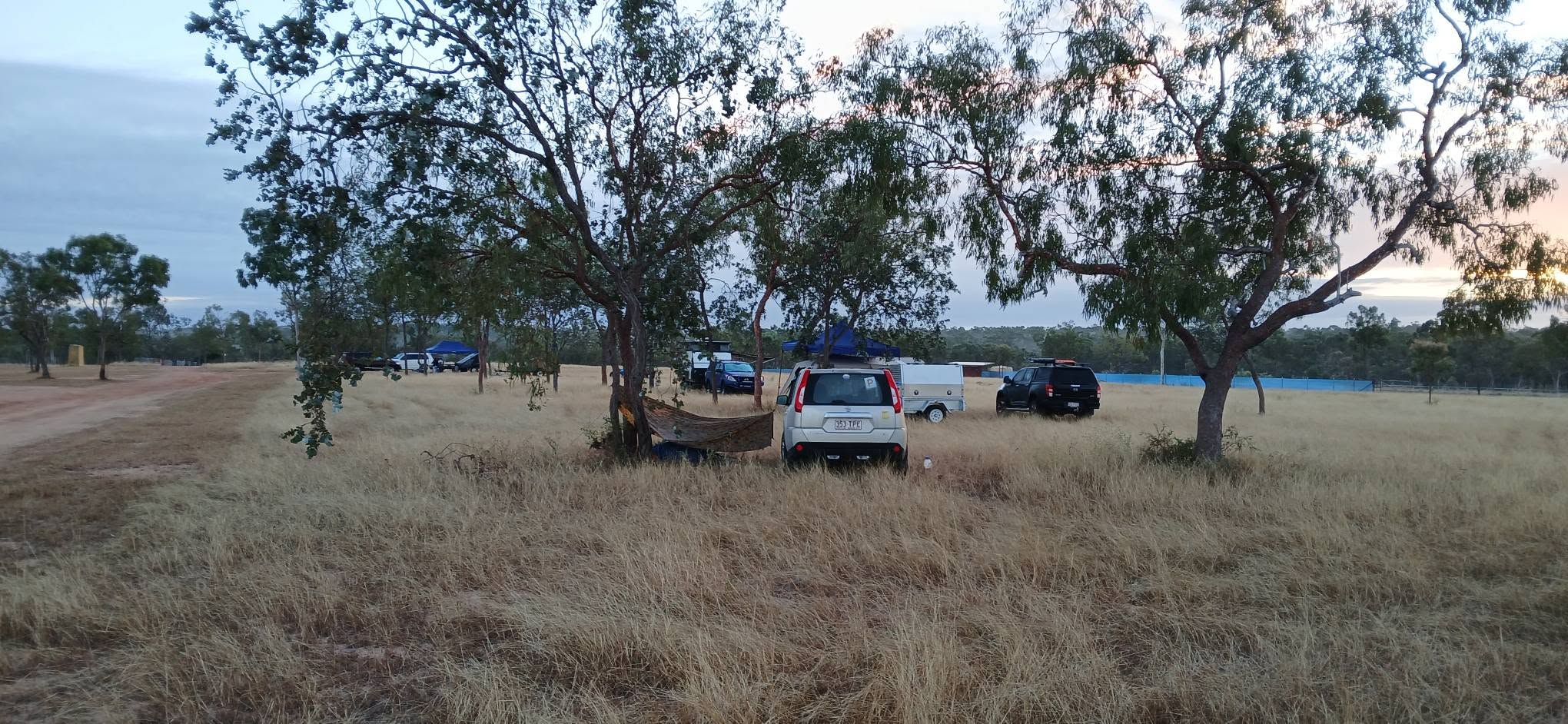 Campsite with vehicles and trailers at dusk