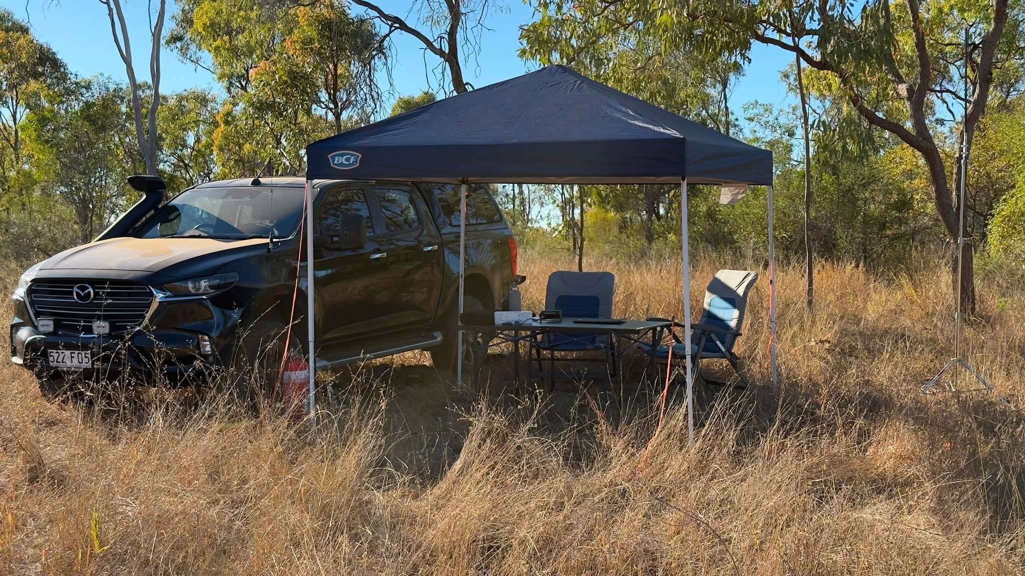 Campsite with radio table set up under a canopy