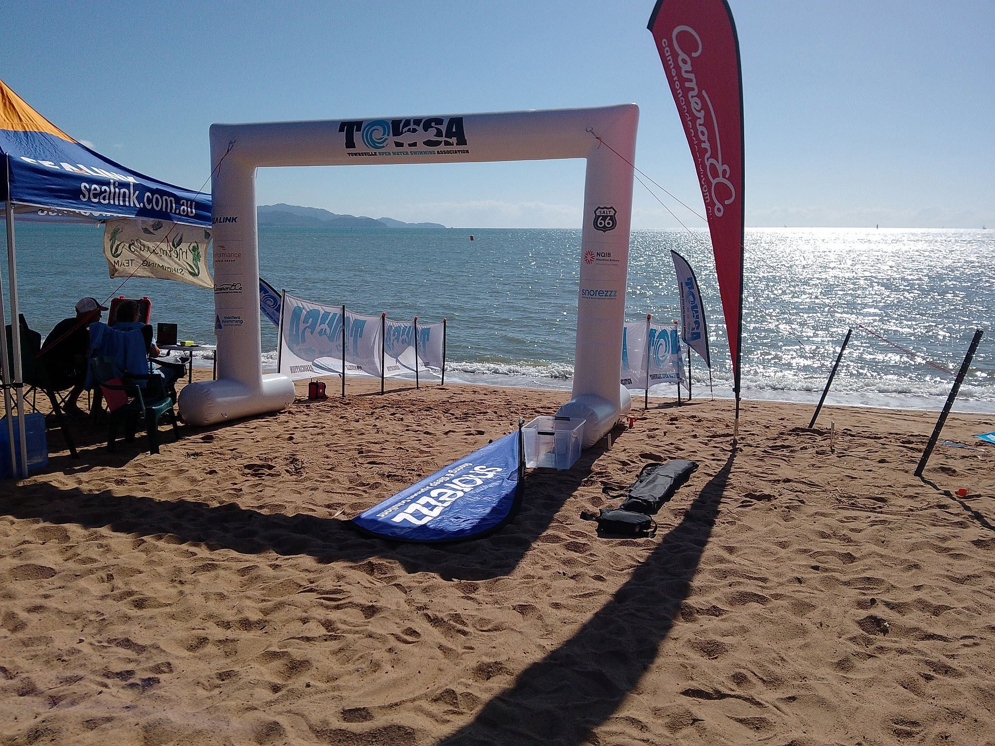 The TOWSA finish arch and Sealink banner on a sunny Strand beach, timing table alongside