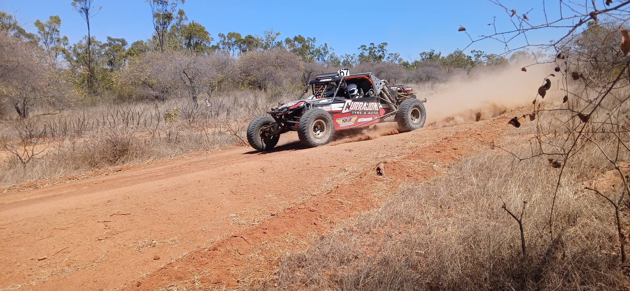 Race buggy kicking up dust on the dirt track