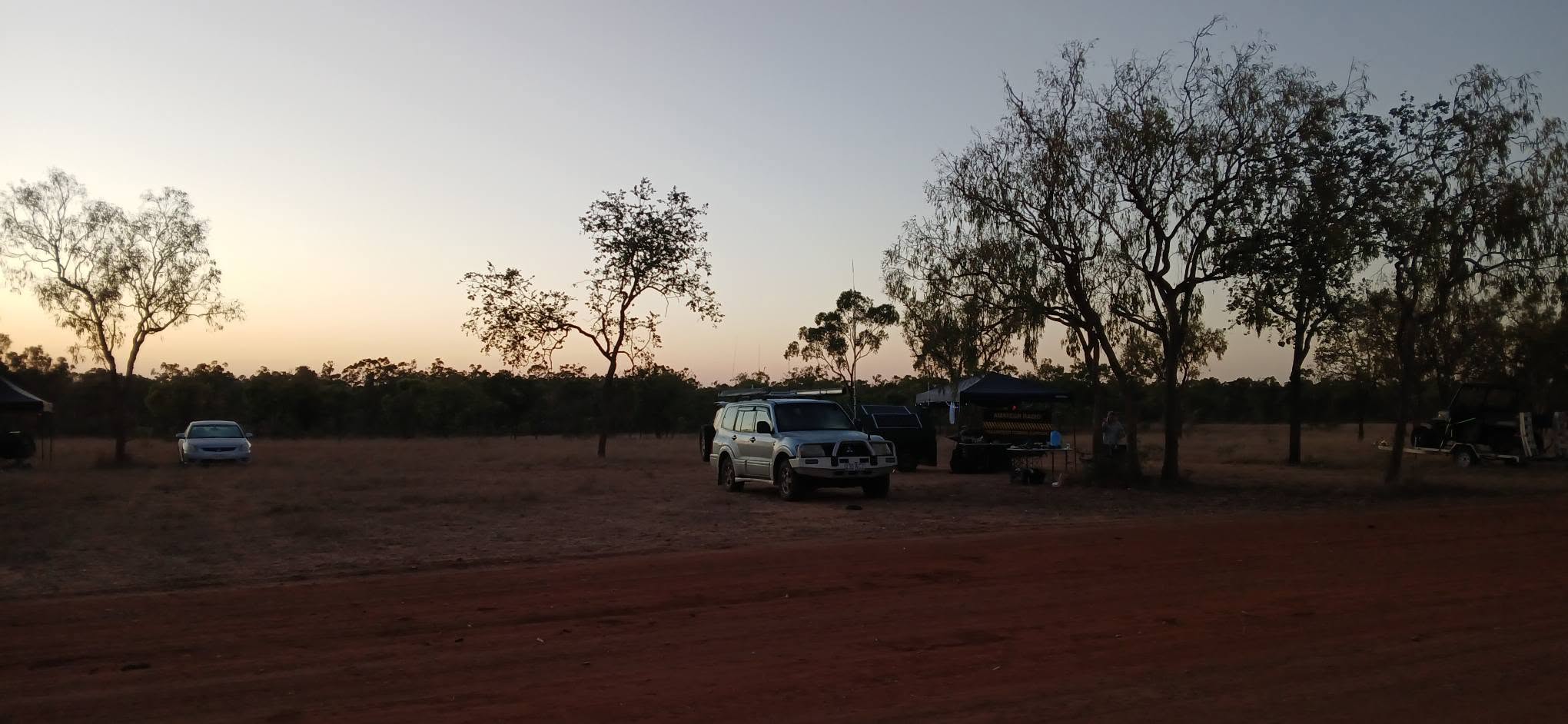 Camp at dusk with a 4WD and gazebos on the flat