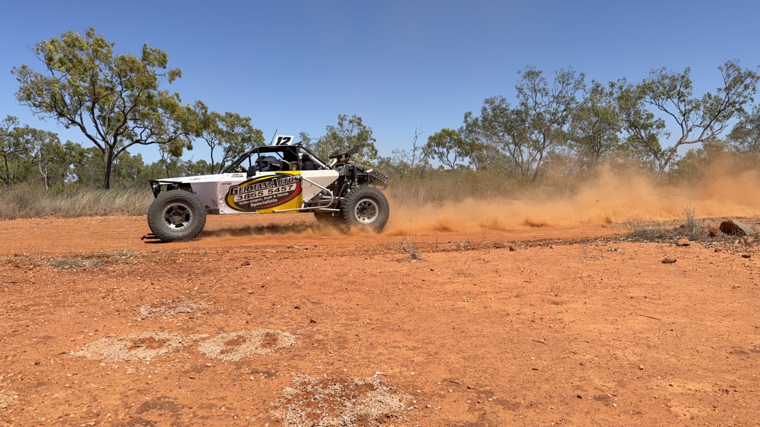 White buggy number 12 kicking up red dust