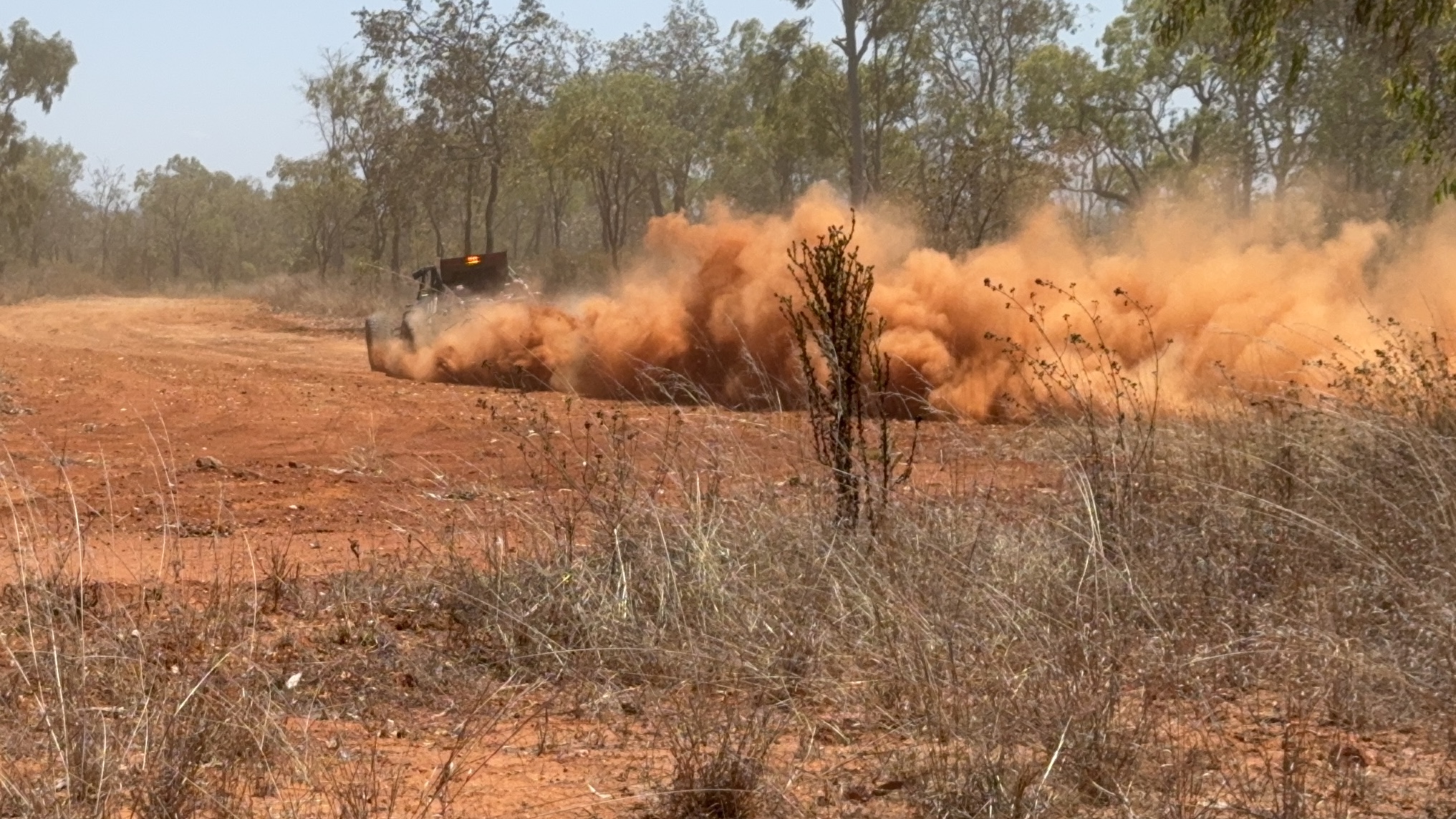 Buggy disappearing into a plume of red dust